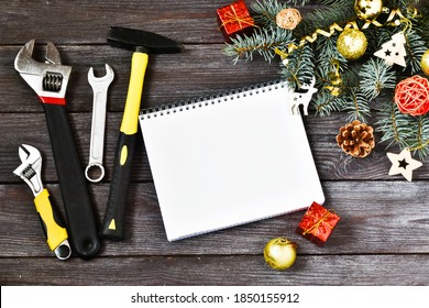 Christmas construction tools. Wrenches, hammer, screwdriver and New Year fir, notepad for text and New Year toys on a wooden background.Construction theme. Copy space, flat lay. Advertising. - Powered by Shutterstock