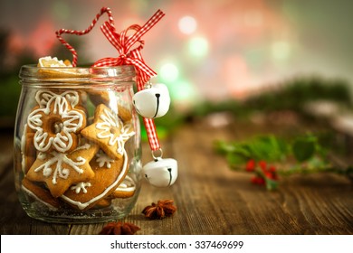 Christmas Cookies in a jar on Wooden background with Christmas Holly