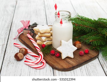 Christmas Cookies And Milk With Decorations On A Wooden Table