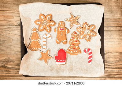 Christmas cookies painted with icing on a baking sheet on a wooden table - Powered by Shutterstock