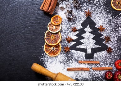 Christmas Cooking: Fir Tree Made From Flour On A Dark Table, Ingredients For Baking And Dried Fruits On Dark Background, Top View