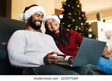 Christmas, couple and couch with laptop, credit card and together for finance, festive season and ecommerce in lounge. Xmas, man and woman for payment, investments and online banking for transactions - Powered by Shutterstock