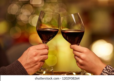 Christmas Couple At Home In Winter. Couple Clinking Glasses And Drinking Red Wine At Home In Christmas Time.