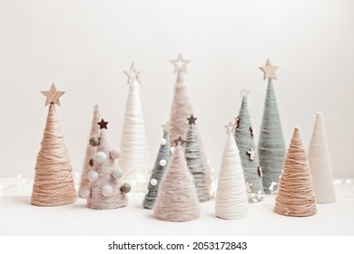 Christmas Craft Background With Handmade Yarn Cone Xmas Trees In Natural Colors.  DIY Organic Sustainable Christmas Decoration