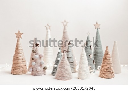 Christmas craft background with handmade yarn cone xmas trees in natural colors.  DIY organic sustainable christmas decoration