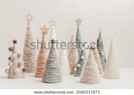 Christmas craft background with handmade yarn cone xmas trees in natural colors.  DIY organic sustainable christmas decoration