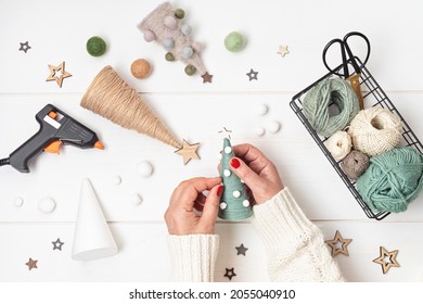 Christmas craft hobby background with handmade yarn cone xmas trees in natural colors. Recomforting, destressing hobby to make christmas decoration. Top view of diy workshop - Powered by Shutterstock