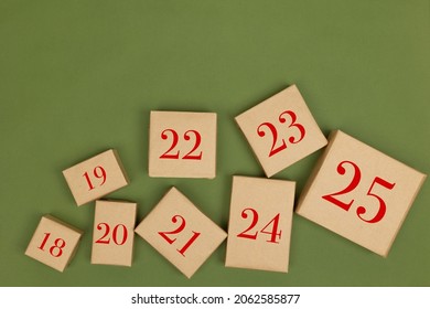 Christmas crafts made of paper holiday boxes on a green background. Christmas winter holiday greetings, advent calendar. flat lying