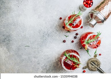 Christmas Cranberry Cocktail In Glasses Decorated With Coconut On Light Gray Festive Background With Fir Branches, Fresh Berries And Rosemary. Holiday Concept. Top View. Flat Lay