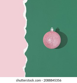 Christmas Creative Layout With Pink Bauble Decoration On Dark Green And Pastel Pink Background. New Year Celebration Creative Idea. Retro Aesthetic Christmas Minimal Concept