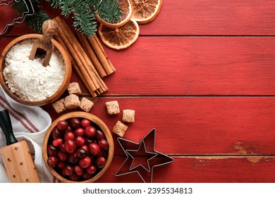 Christmas culinary background with ingredients for cooking christmas baking cranberries, sugar, cinnamon and Christmas tree branches on rustic old red wooden table background.Top view copy space. - Powered by Shutterstock