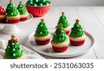 Christmas cupcakes with green frosting on a white wooden table.