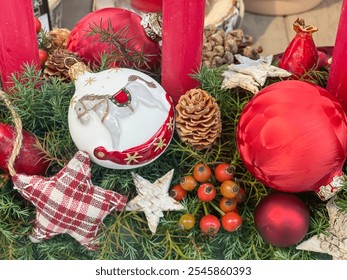 Christmas deco arrangement with red balls and a white horse ball in natural pine branches cones, textile star red candle, berries. cozy concept, December holidays garland, wreath

 - Powered by Shutterstock