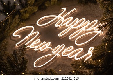 Christmas decor. A flexible neon sign with the words Happy New Year hanging on the wall. Around the wreath of Christmas tree branches. Celebration of new year, christmas - Powered by Shutterstock