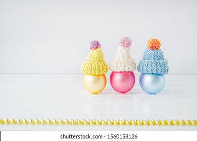 Christmas decoration balls and garland on a white background. Three colored balloons in a cap in the form of snowmen. Place for text. Christmas composition.