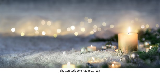Christmas decoration with candle, lights, fir branches and ornaments on snow, panoramic format - Powered by Shutterstock