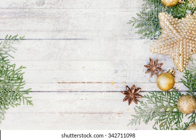 Christmas Decoration. Golden Balls, Star, Anise And Fir Tree Branches On The White Snowy Wooden Background.