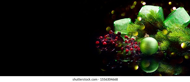 Christmas Decoration Isolated On Black. Wide Screen Backdrop. Border Art Design With Holiday Baubles. Beautiful Christmas Tree Closeup Decorated With Ball, Holly Berry, Green Ribbon. Xmas Art Design