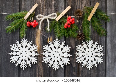 Christmas decoration over wooden background. Snowflakes are hanging. - Shutterstock ID 150649016