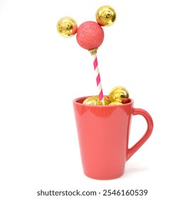 Christmas decoration. Red mug with golden Christmas balls. Red ball with yellow ears, a striped paper straw as a stand. White background. Creative and Christmas minimal, concept. - Powered by Shutterstock