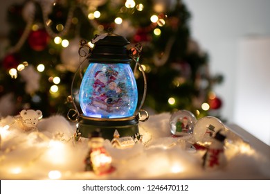 Christmas Decoration, Snow Dome, Globe With Table Decoration, Santaclaus On Sleigh With Child In Winter Scene With Snowflakes, Reindeer Snowglobe And Polar Bears, Tree In Background