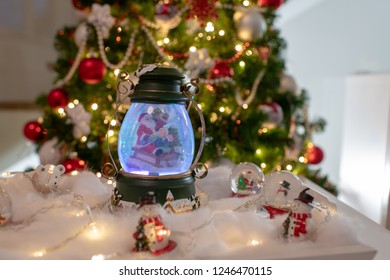 Christmas Decoration, Snow Dome, Globe With Table Decoration, Santaclaus On Sleigh With Child In Winter Scene With Snowflakes, Reindeer Snowglobe And Polar Bears, Tree In Background