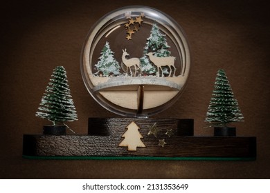 Christmas decoration. Snow globe with fir trees and deer on brown background - Powered by Shutterstock