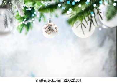 Christmas decoration with white christmas balls and fir tree branches against blurred blue background, copy space for your product or text. - Shutterstock ID 2207021803