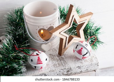 Christmas decoration with white jingle bells and candle on white rustic background - Powered by Shutterstock