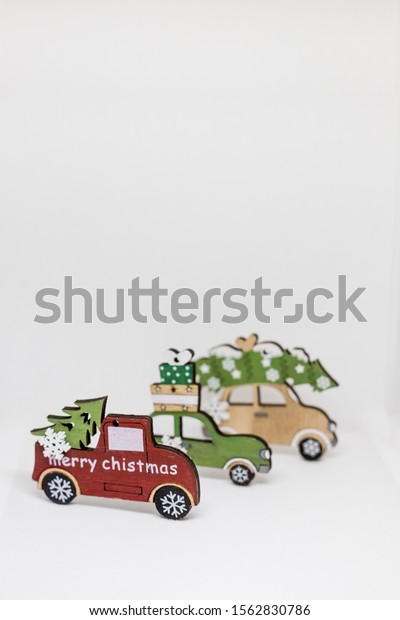 Christmas decoration with wooden cars, gifts with\
copy space. Season greeting card, party invitation, christmas\
celebration concept. Winter holidays.Toy car carrying a Christmas\
tree.Copy space