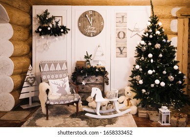 Christmas Decorations: Chair, Christmas Tree, Chest Of Drawers, Clock, Gifts On The Background Of A Wooden Wall. Christmas Photo Zone. Christmas Photo Zone