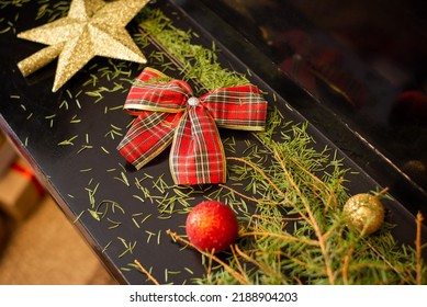 Christmas Decorations And Fir Tree Needles On Black Piano. Mess After Christmas Holidays, Cleaning House After Christmas Holidays