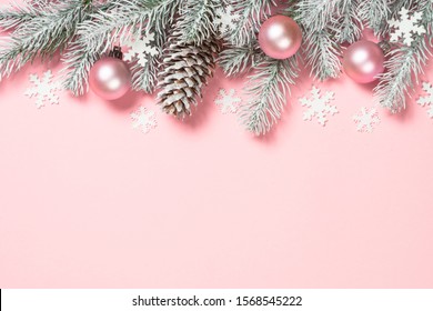 Christmas decorations and fir tree on pink background. Top view with copy space.
