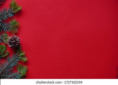 Christmas decorations layout or flatlay with fir branches and cones on red background.Eco natural frame. winter, new year Holidays concept as top view, copyspace. greeting card template