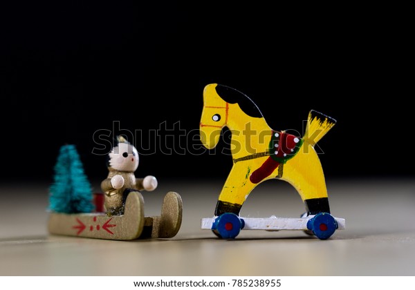 Christmas\
decorations made of wood on a wooden table. Christmas decorations\
and small Christmas presents. Black\
background.