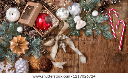 Christmas decorations on fir-tree branches and gifts on wooden background