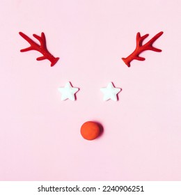 Christmas decorative elements, creative layout against pastel pink background. Christmas tales inspiration. Reindeer with red nose idea. 