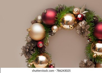 Christmas Decorative Wreath with Fir Branch and Red Globes on Beige background with Copy Space.