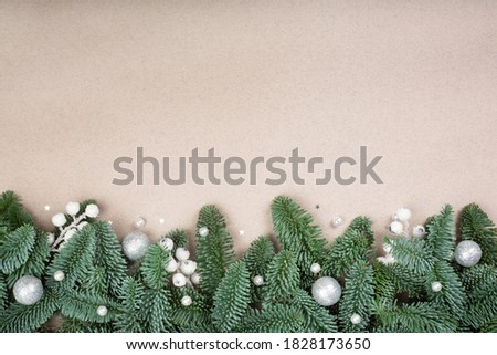 Christmas design boder frame greeting card of noble fir tree branches gift and baubles on craft paper background