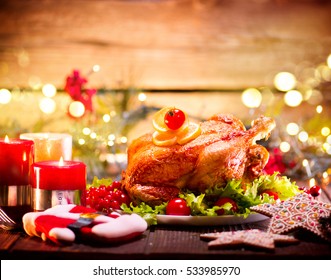 Christmas Dinner. Roasted Chicken. Winter Holiday Table Served, Decorated With Candles. Roast Turkey Over Wooden Background With Christmas Tree, Table Setting. 