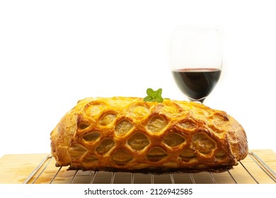 christmas dinner served on grill fillet wellington wrapped with a thin golden layer of fresh puff pastry and mint leaves next to red wine