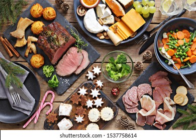 Christmas Dinner Table With Roast Beef, Appetizers Platter And Traditional Cookies. Christmass Celebration, Festive Family Dinner.  Overhead View.