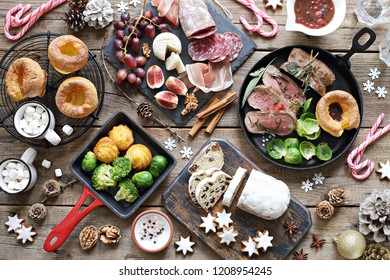 Christmas dinner table with roast beef,yorkshire pudding,appetizers platter and traditional cake. Christmass celebration, festive family dinner.  Overhead view.