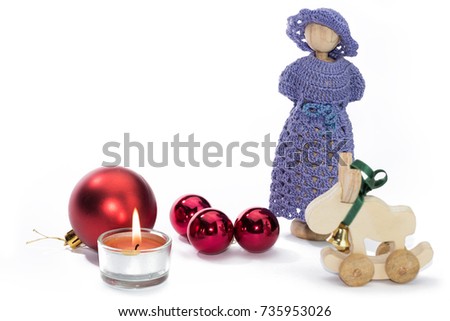 Christmas doll figures with candle and red balls against white background