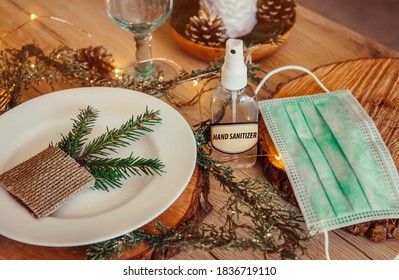 Christmas Eve Holiday Party Decorated Table Set With Disposable Medical Mask And Alcohol Hand Sanitizer Bottle. Coronavirus (Covid 19) Spreading Prevention Concept. Christmas Micro Led Lights Wire.