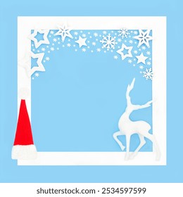 Christmas Eve magical background with santa hat and reindeer decoration on blue, white frame stars and snowflakes. North Pole winter wonderland concept - Powered by Shutterstock