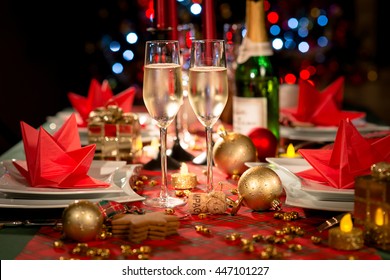 Christmas Eve Party Table With Champagne Flute With Red And Golden Glitter