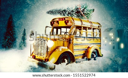 Christmas eve snow scene with yellow bus carrying a pine tree for decorating to celebrate the holiday through a winter snowstorm at night with copy space for a seasonal greeting