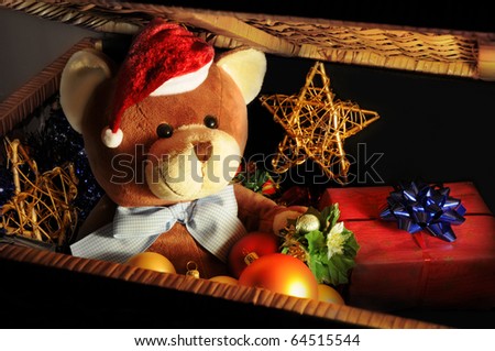 Christmas expectations concept - teddy bear in a dark chest with Christmas decoration and gifts.