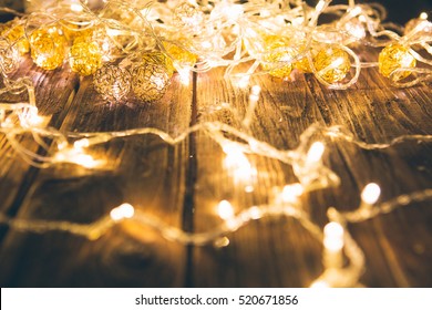 Christmas Fairy Lights On A Wooden Table To Be Used As Background Or Texture.